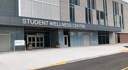 An exterior photo of the Student Wellness Centre. Text on the building states, Student Wellness Centre.