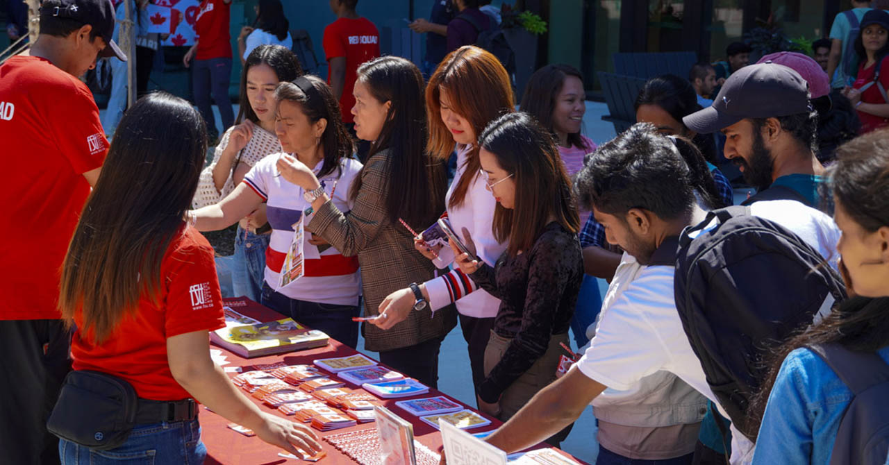 A group of students gathered in front of an info table.