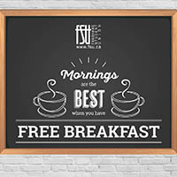 Chalkboard sign with steaming coffee cups reads Mornings are the best when you have free breakfast against a white brick wall.