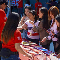 A group of students gathered in front of an info table.