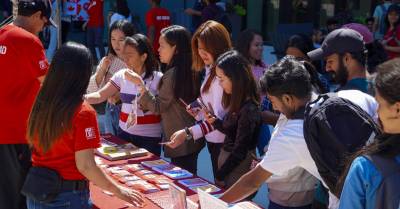 A group of students gathered in front of an info table.