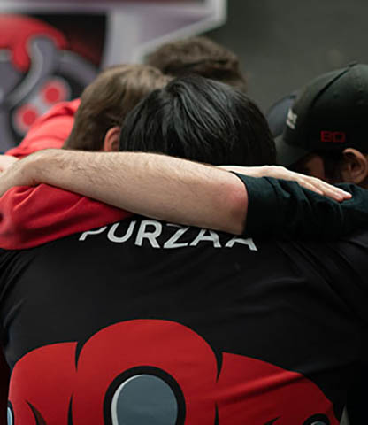 Team members in a group hug showing support during an esports event