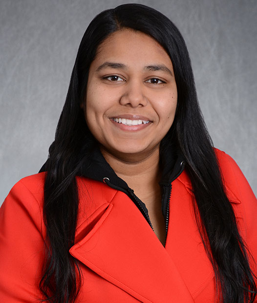 A headshot of Benazir Shelk Ahamed in front of a grey background.