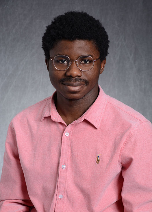 A headshot of Samuel Nelly Ismaila in front of a grey background.