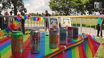Drinks on a table with a rainbow tablecloth on a patio.